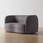 Divanetto curvo in tessuto bouclé Boho con cuscini a molle insacchettate