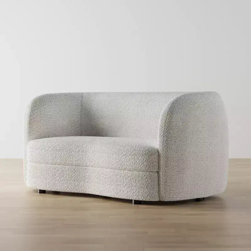 Divanetto curvo in tessuto bouclé Boho con cuscini a molle insacchettate